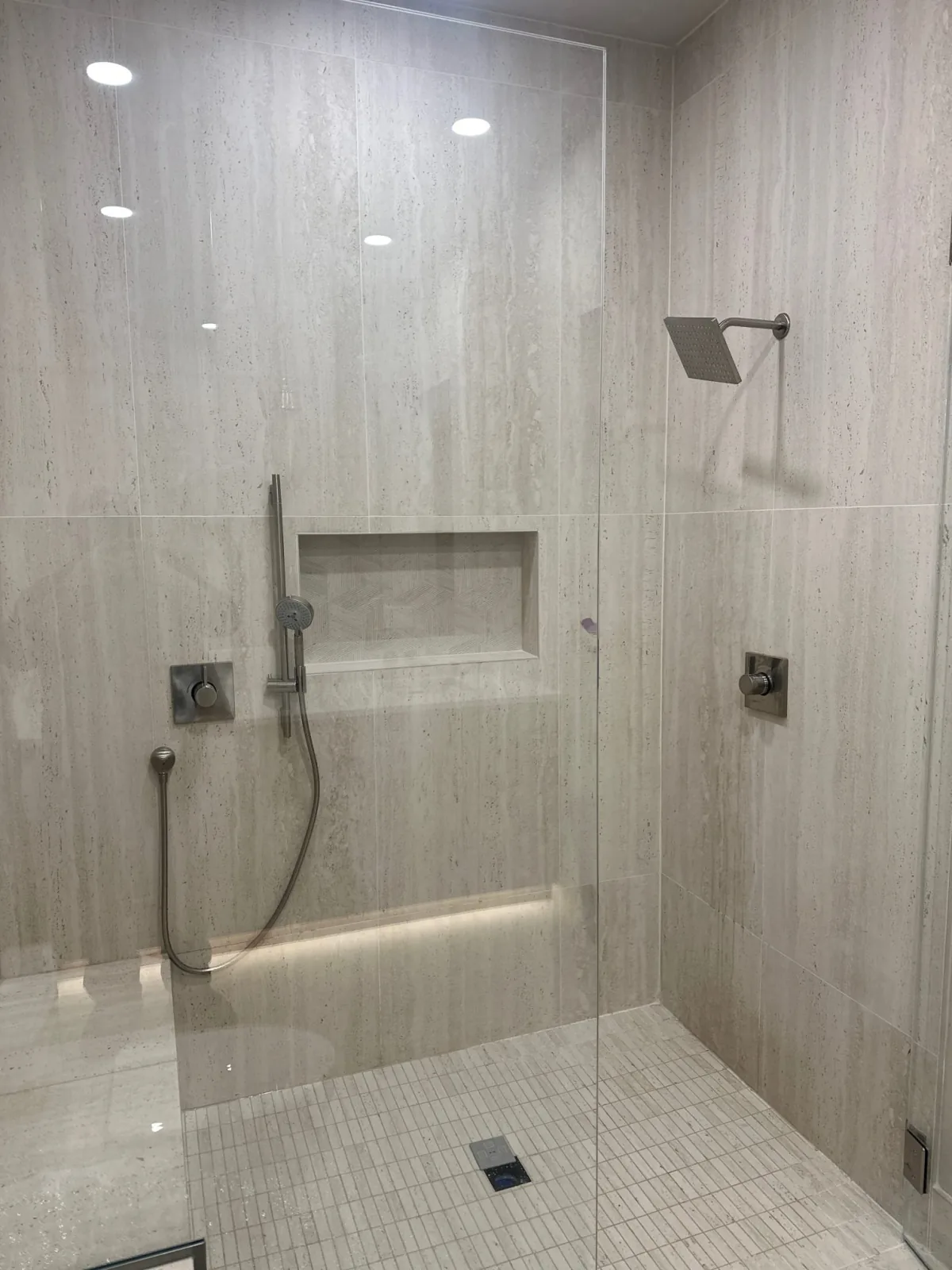 Finished walk-in shower with tiled walls and glass enclosure